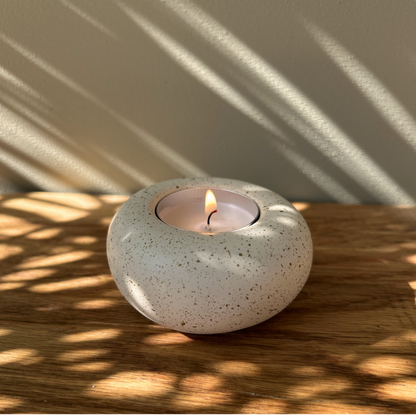 Cast stone Sanctuary tealight holder shown alone with lit tealight