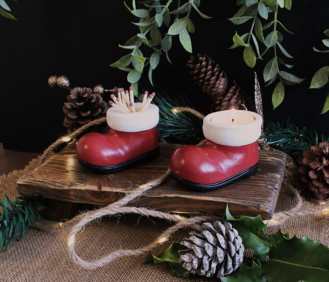 Two Santa boots on a wooden platform with greenery