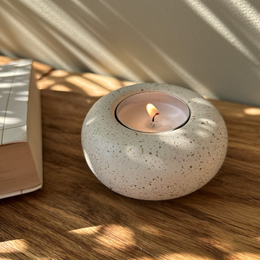 Cast stone Sanctuary tealight holder with lit tealight, featured product shot